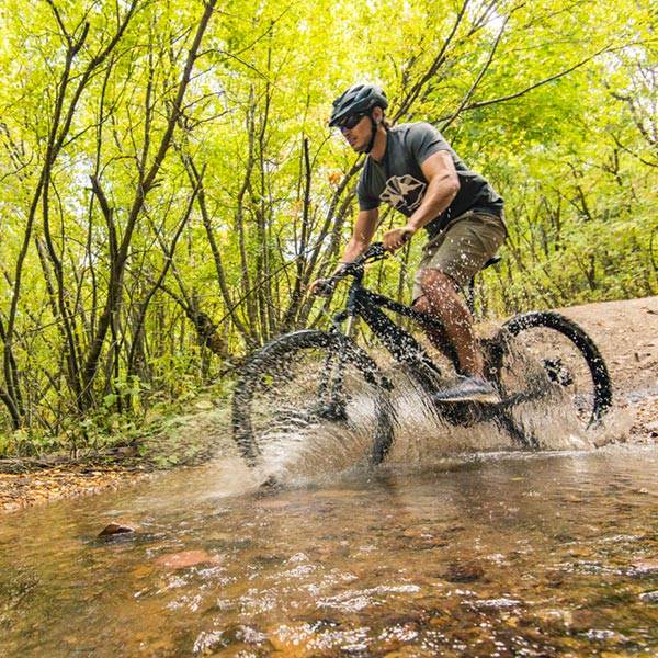 Mountain biker riding through shallow stream