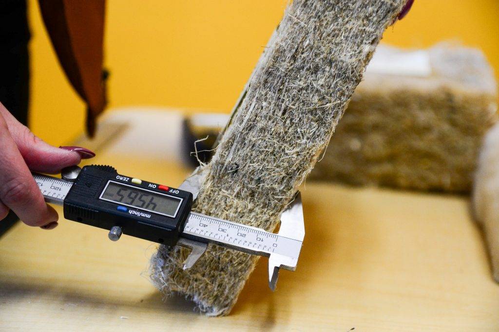 A student measures the fiberbatt insulation