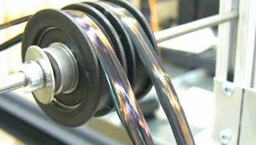 A close-up of a mechanical device with spinning, iridescent black ribbons