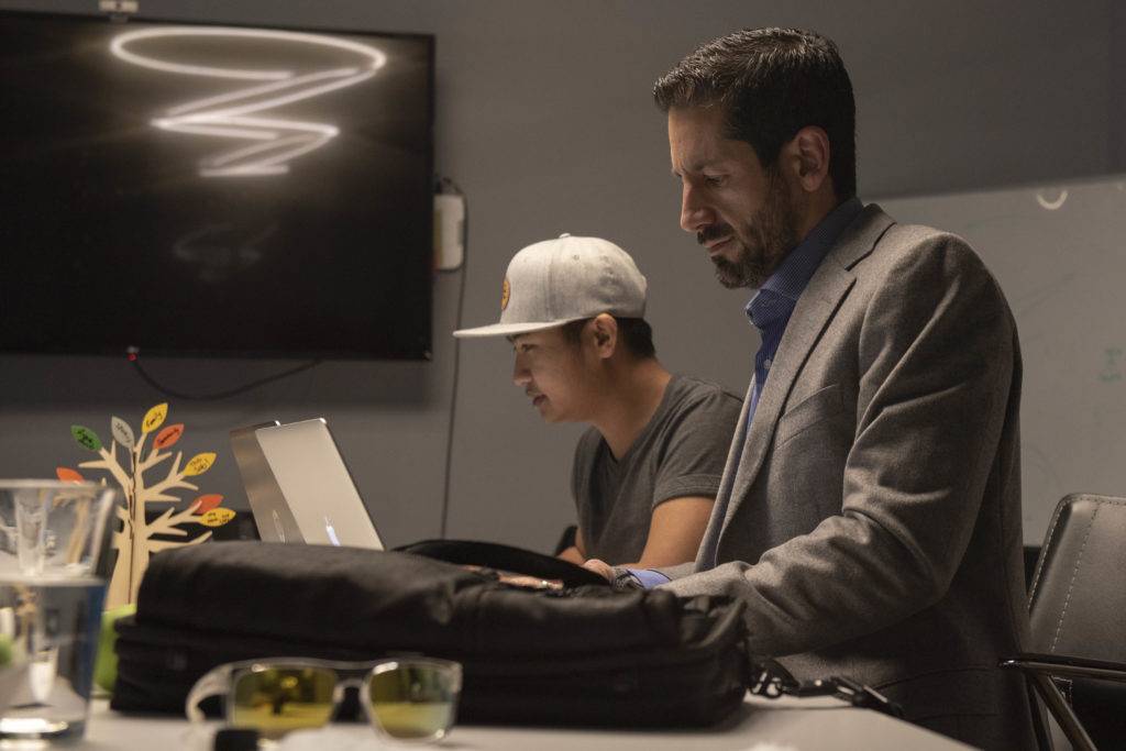 Two men are working on laptops in a modern office with a minimalist design