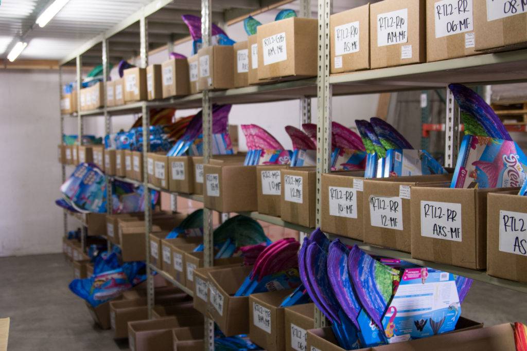 A storage facility with shelves filled with colorful boxes labeled with codes