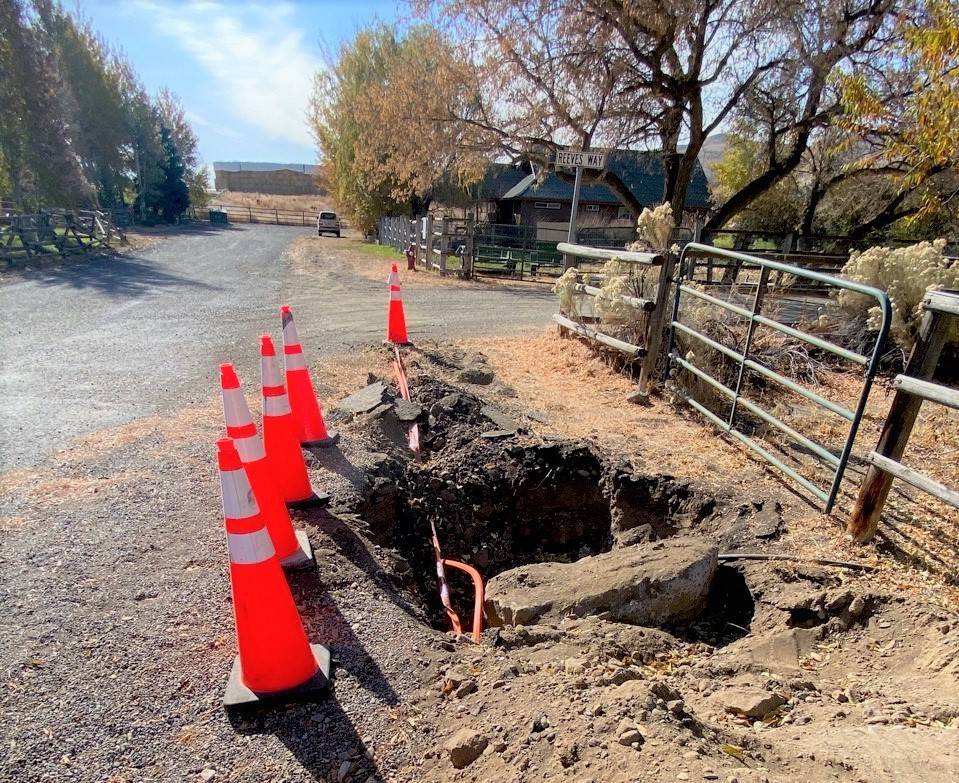 Construction site with orange traffic cones and exposed underground utility pipes