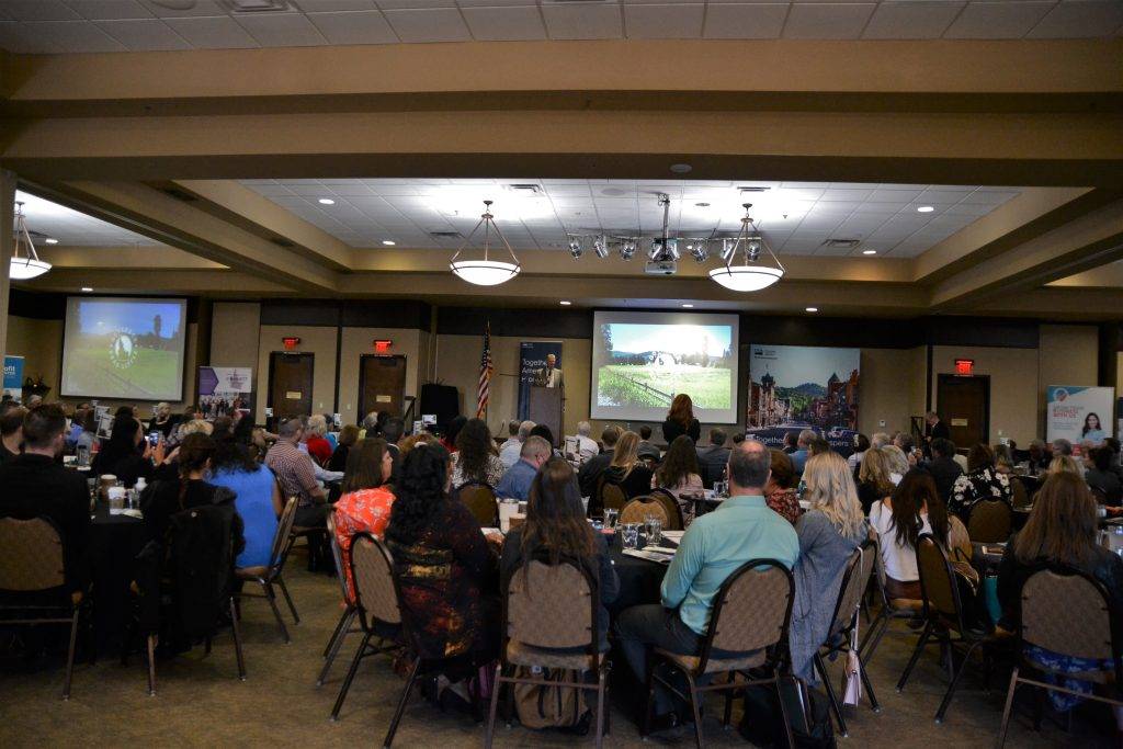 Governor Little provides opening remarks in a room full of people.