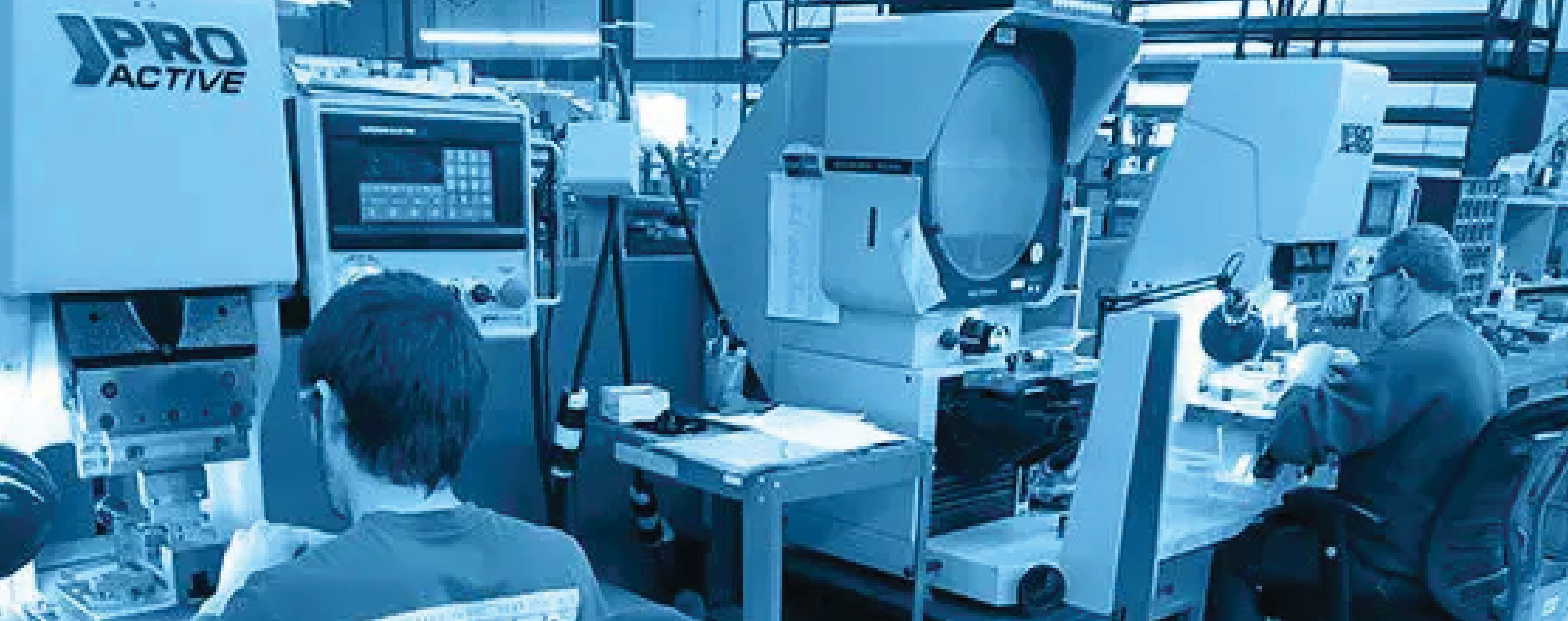 Workers operate precision machinery in a manufacturing facility