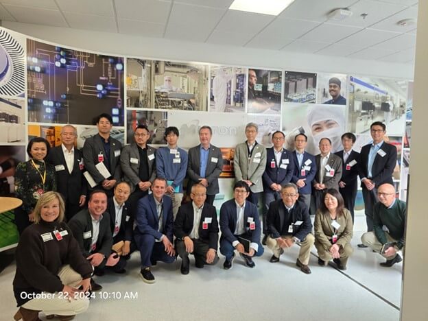 A diverse group of professionals poses for a photo in a lab or office setting